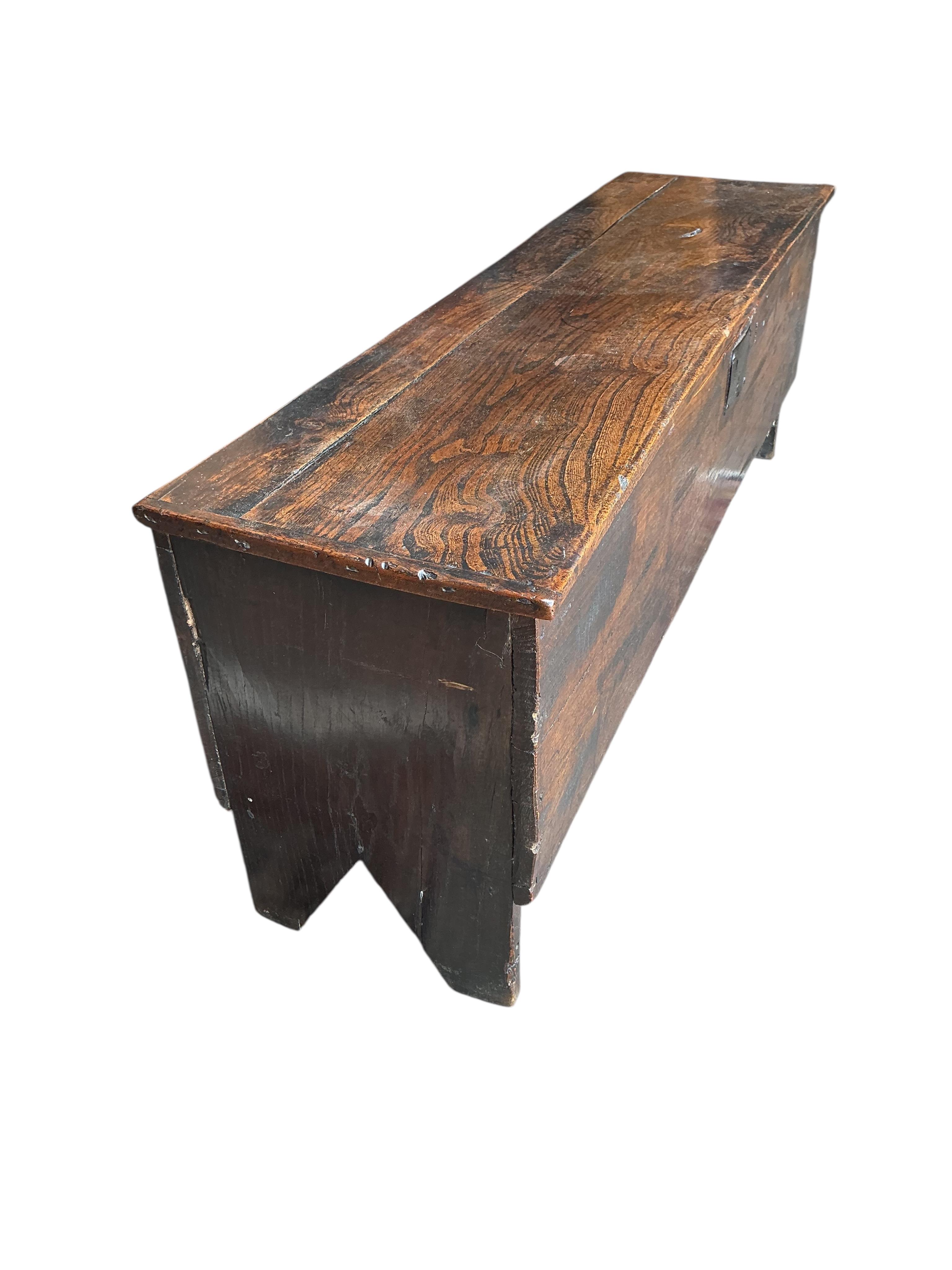 An early 18th century elm six plank coffer, width 136cm, depth 35cm, height 49cm